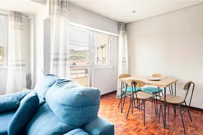 a living room with a blue couch and a table at Apartamento en el centro de Ourense in Ourense