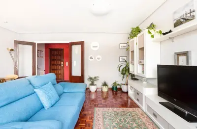 a living room with a blue couch and a flat screen tv at Apartamento en el centro de Ourense in Ourense