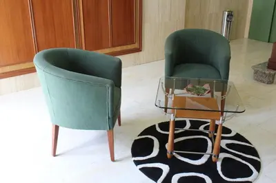 two green chairs and a glass table in a room at Hotel Casa Benilde in Palas de Rei