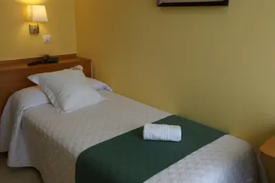 a hotel room with a bed with a towel on it at Hotel Casa Benilde in Palas de Rei