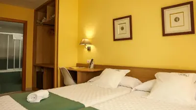 a hotel room with a bed and a desk at Hotel Casa Benilde in Palas de Rei