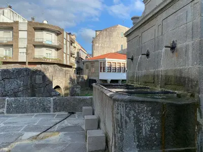a water fountain in a city with buildings at Home Sweet Home in Caldas de Reis