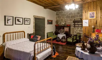 a bedroom with a bed and a stone wall at Casa do Pacio Sabadelle in Lugo