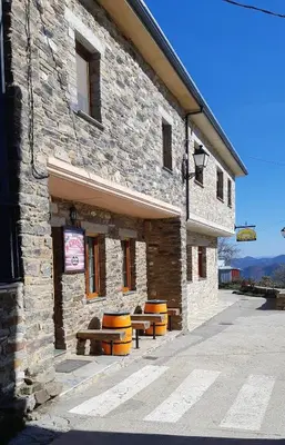 a stone building with benches in front of it at Albergue la escuela in La Laguna