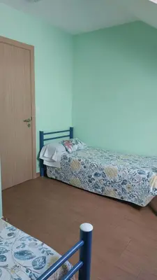 a bedroom with a bed and a door in a room at Albergue la escuela in La Laguna