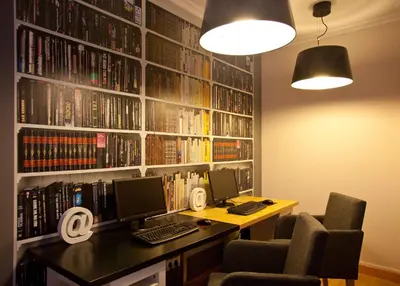 a library with a desk with two computers and books at Hotel Palacio de Cristal in Burela de Cabo