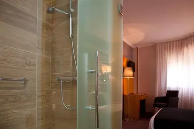 a bathroom with a shower with a glass door at Hotel Palacio de Cristal in Burela de Cabo