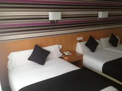 two beds sitting next to each other in a room at Hotel Palacio de Cristal in Burela de Cabo