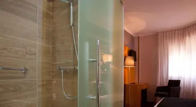 a bathroom with a shower with a glass door at Hotel Palacio de Cristal in Burela de Cabo