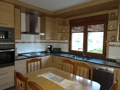a kitchen with a wooden table and a table and chairs at Sandino 32 in Santiago de Compostela