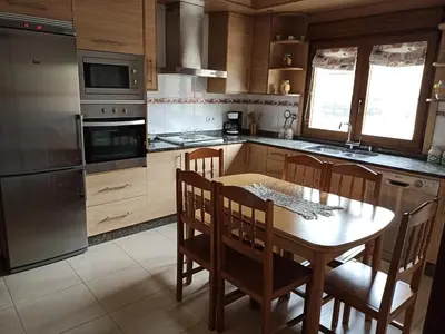 a kitchen with a table and chairs and a refrigerator at Sandino 32 in Santiago de Compostela