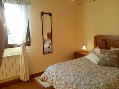 a bedroom with a bed and a mirror and a window at Casa Rural Las Nieves in San Ciprián