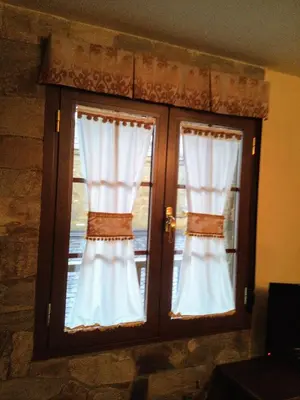 two windows with white curtains in a room at Casa Rural Las Nieves in San Ciprián
