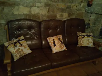 a brown leather couch with pillows with a number one on it at Casa Rural Las Nieves in San Ciprián