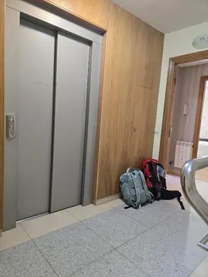 a bag of luggage sitting on the floor next to a door at Noja rooms 2 in O Pedrouzo