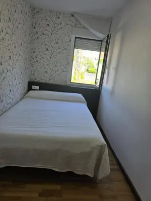 a small bedroom with a bed and a window at Noja rooms 2 in O Pedrouzo