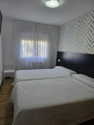 a bedroom with two beds and a window at Noja rooms 2 in O Pedrouzo