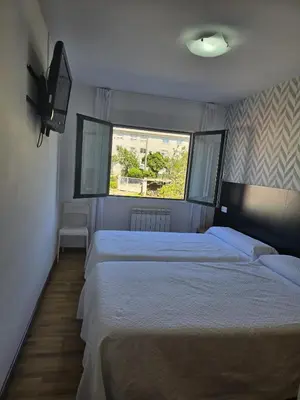 a bedroom with two beds and a window at Noja rooms 2 in O Pedrouzo