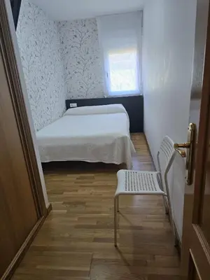 a small bedroom with a bed and a chair at Noja rooms 2 in O Pedrouzo