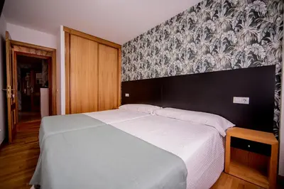 a bedroom with a large white bed with a wallpaper at Noja rooms 2 in O Pedrouzo