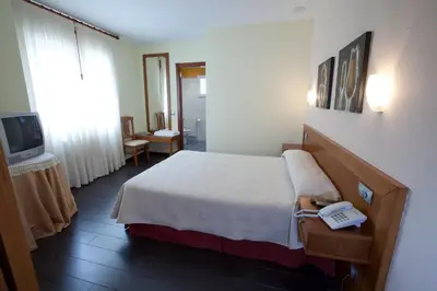 a hotel room with a bed and a telephone at Hotel TERRANOVA in Oza dos Ríos