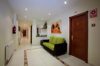 a living room with a green couch in a hallway at Hotel TERRANOVA in Oza dos Ríos