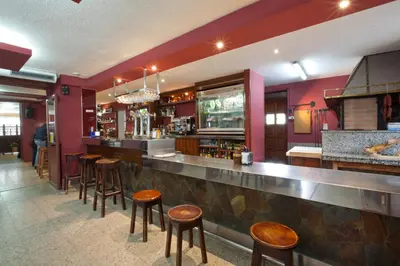 a bar with wooden stools in a restaurant at Hotel TERRANOVA in Oza dos Ríos