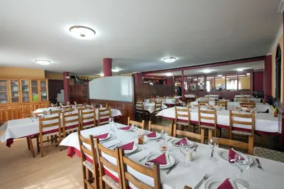 a dining room with tables and chairs with white tablecloths at Hotel TERRANOVA in Oza dos Ríos