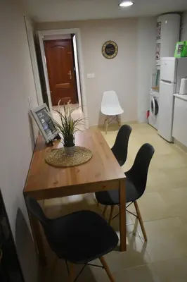 a kitchen with a wooden table with chairs and a table sidx sidx sidx at A Casa do Calexón in Viveiro