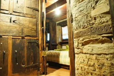 a room with a bed and a wooden door and a bedroom at Casa O´Crego in San Román