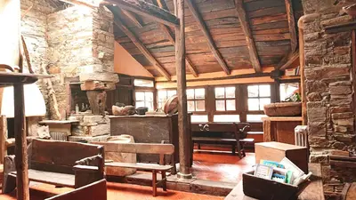 a living room with a stone building with a table and chairs at Casa O´Crego in San Román
