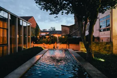 a pond in front of a building with a tree at Inferniño Apartments in Santiago de Compostela