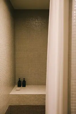 two black bottles sitting on a shelf in a shower at Inferniño Apartments in Santiago de Compostela