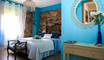 a blue bedroom with a bed and a mirror at A Lume Manso - Adults Only in Barreiros