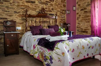 a bedroom with a bed with a wooden headboard and purple walls at A Lume Manso - Adults Only in Barreiros