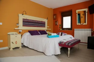 a bedroom with a large bed and a chair at A Lume Manso - Adults Only in Barreiros