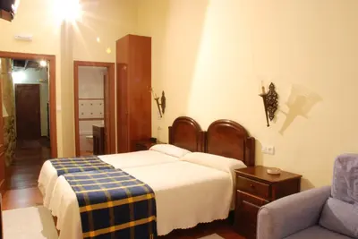 a hotel room with a bed and a chair at Hotel O Portelo Rural in Allariz