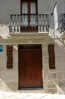 a building with a wooden door and a balcony at Hotel O Portelo Rural in Allariz