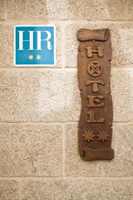 a sign on the side of a brick wall at Hotel O Portelo Rural in Allariz