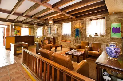 a lobby with couches and chairs in a building at Hotel O Portelo Rural in Allariz