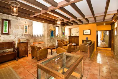 a large living room with chairs and a piano at Hotel O Portelo Rural in Allariz