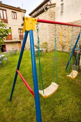 a swing set in a yard at Hotel O Portelo Rural in Allariz