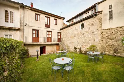 a patio with tables and chairs in a yard at Hotel O Portelo Rural in Allariz
