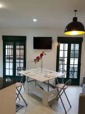 a dining room with a table with a flower on it at A Casiña do Leo in Ourense