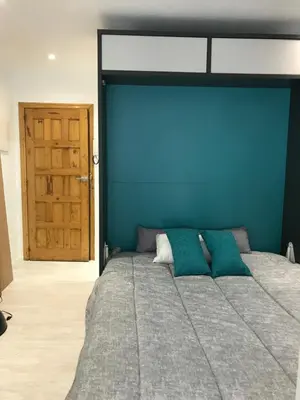 a bedroom with a large bed with a blue wall at A Casiña do Leo in Ourense