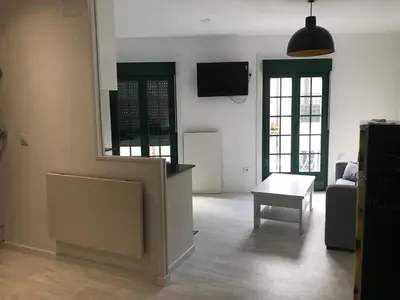 a living room with a couch and a table and a tv at A Casiña do Leo in Ourense