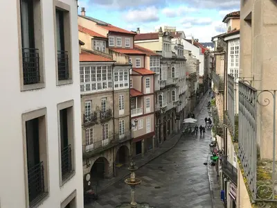 a city street with buildings and people walking down the street at A Casiña do Leo in Ourense