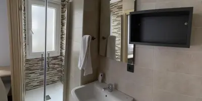 a bathroom with a tub and a tv on the wall at Pensión A Carballeira in Villalba