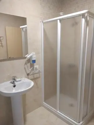 a bathroom with a shower and a sink at Pensión A Carballeira in Villalba