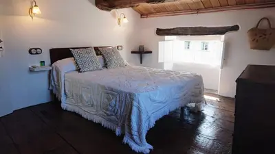 a bedroom with a bed with a blue blanket and a window at Camino de Estrellas Mondoñedo Lugo in Mondoñedo